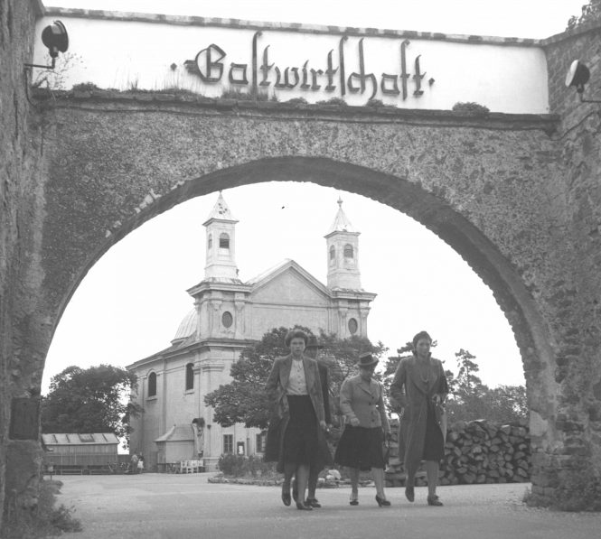 Bild der Kirche am Leopoldsberg durch das Burgtor mit Personen